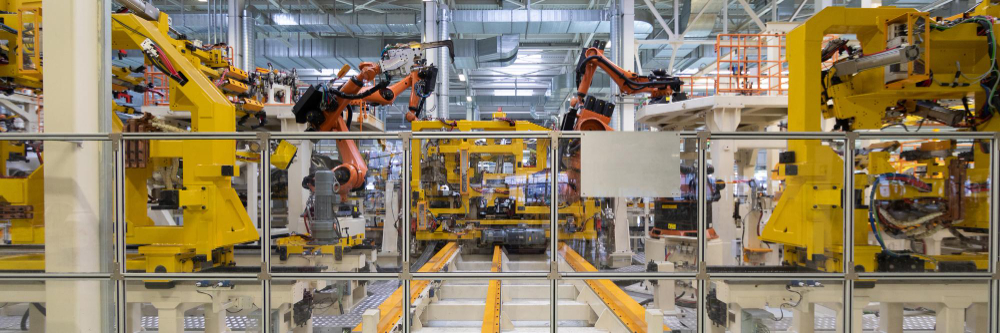 industriehalle-produktion-automatisierung-kaernten image Moderne Industriehalle mit automatisierter Produktionslinie und Robotern für industrielle Fertigung in Kärnten